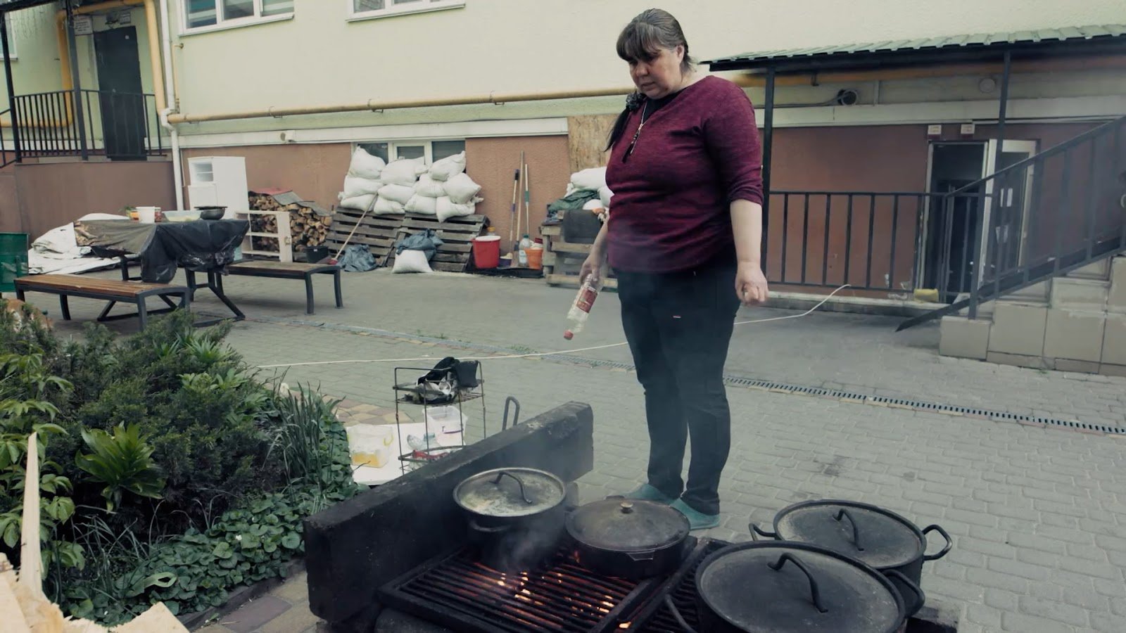 Кадр з фільму. Ірпінчанка готує їжу у дворі
