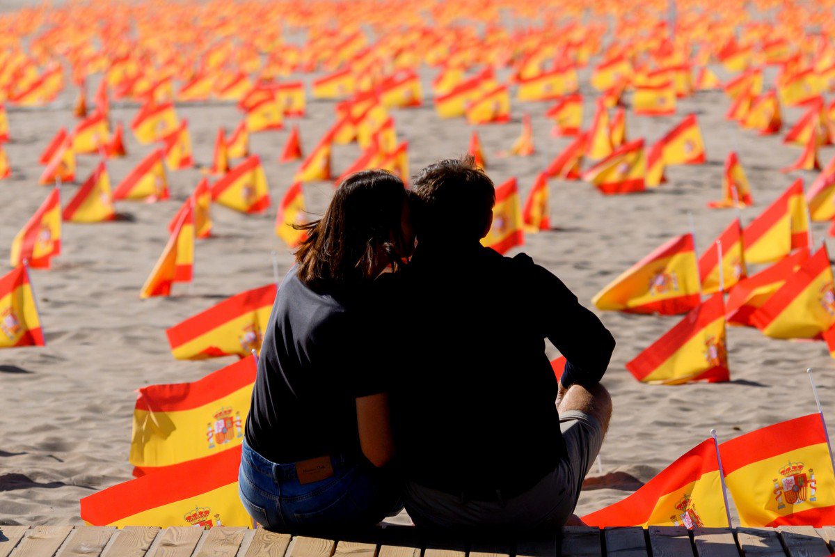 Пара сидить біля тисяч прапорців, які позначають померлих від Covid-19 в Іспанії: Валенсія, 4 жовтня 2020, фото AFP