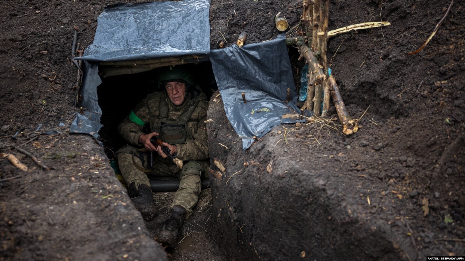 Український піхотинець 57-ї окремої мотопіхотної бригади сидить в окопі на Сході України