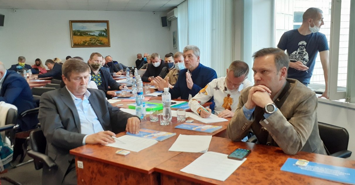 Перевізник Валерій Іваненко (четвертий справа, сивий в синьому костюмі) марно намагається змусити місцеву поліцію зупинити роботу перевізників-нелегалів