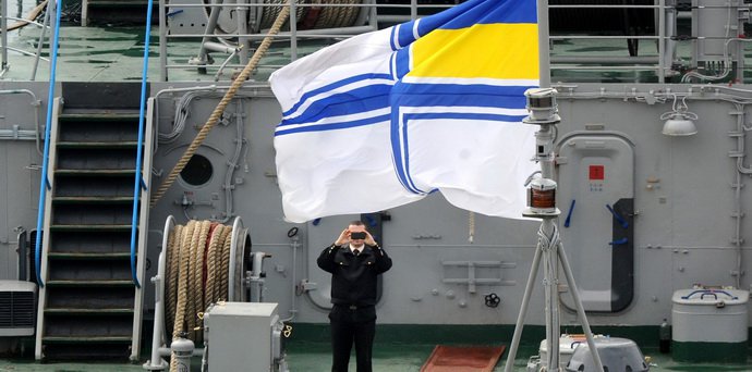 Росія викрала більшу частину українського флоту під час анексії Криму. Це фото зроблене 20 березня 2014 року — на ньому український офіцер фотографує прапор ВМС на борту "Славутича", одного з кораблів, які ми втратили. AFP/EAST NEWS