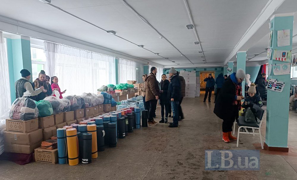 Максим Бахматов з громадою району розвантажує гуманітарну допомогу в опорній школі на Троєщині. Фото: Лівий берег