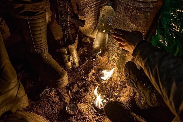 A soldier warms himself with trench candles. Photo: Kostiantyn and Vlada Liberov