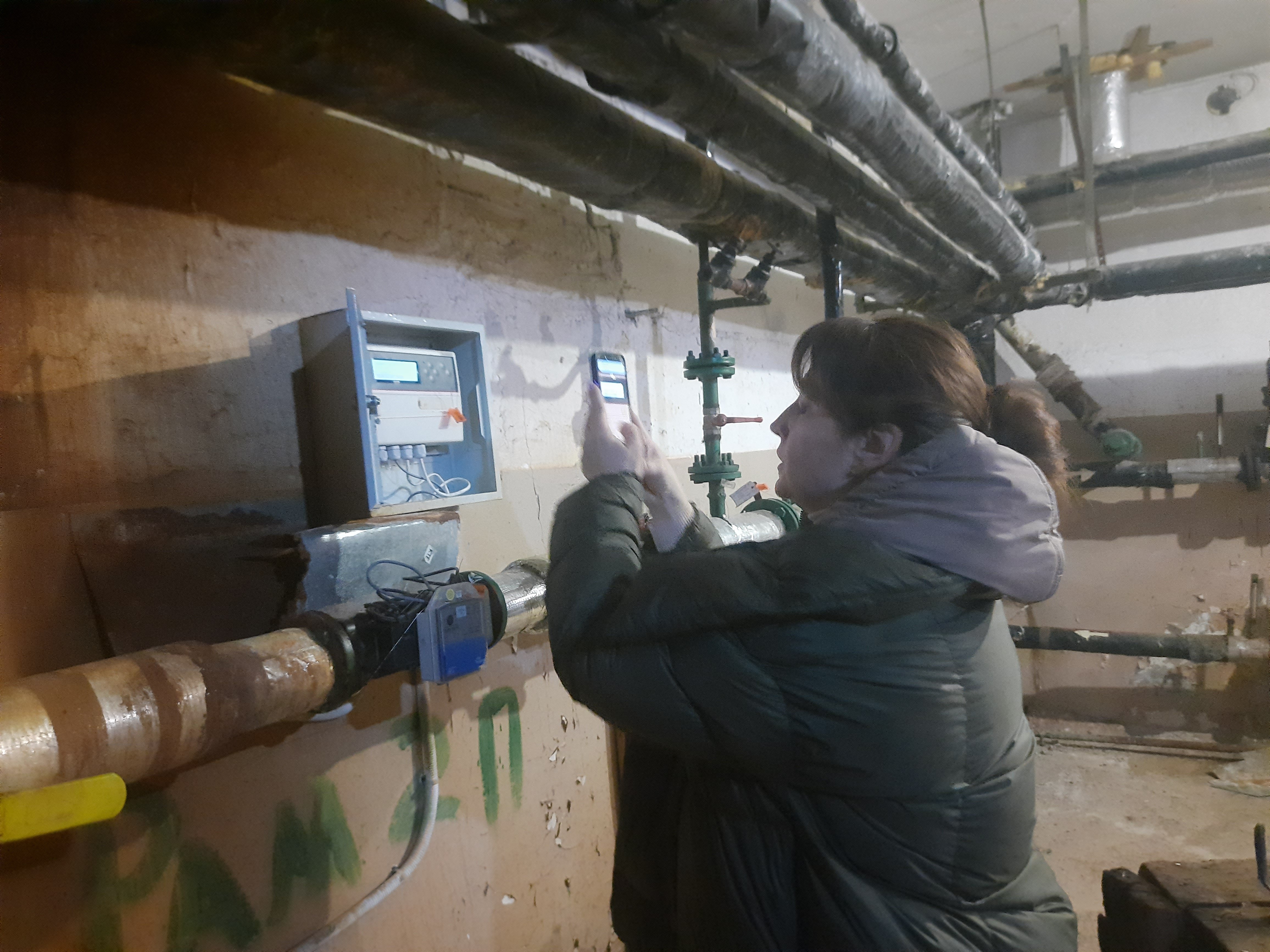 Дар’я Павловська фотографує прилади будинкового теплопункту