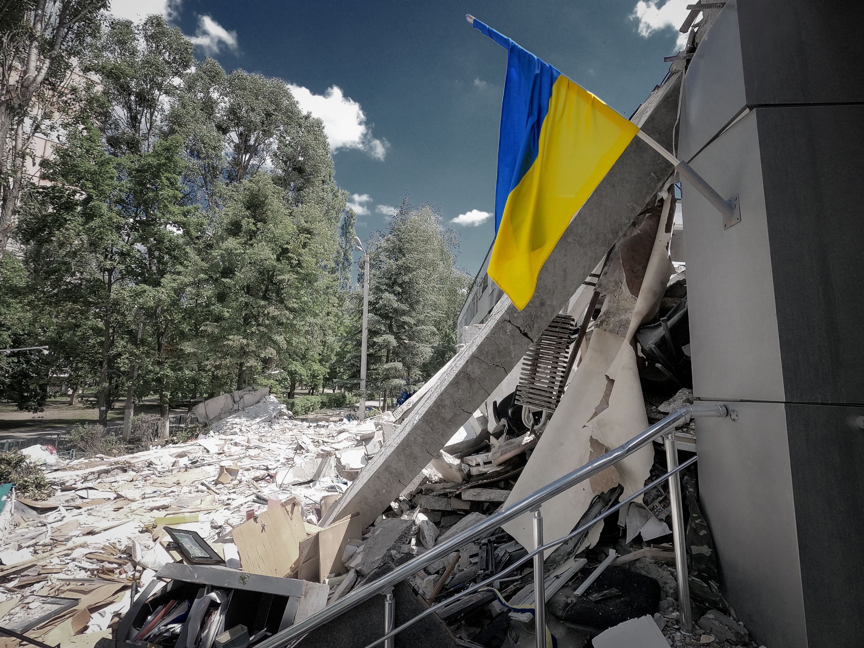 Ukrainian flag remains intact over the damaged building