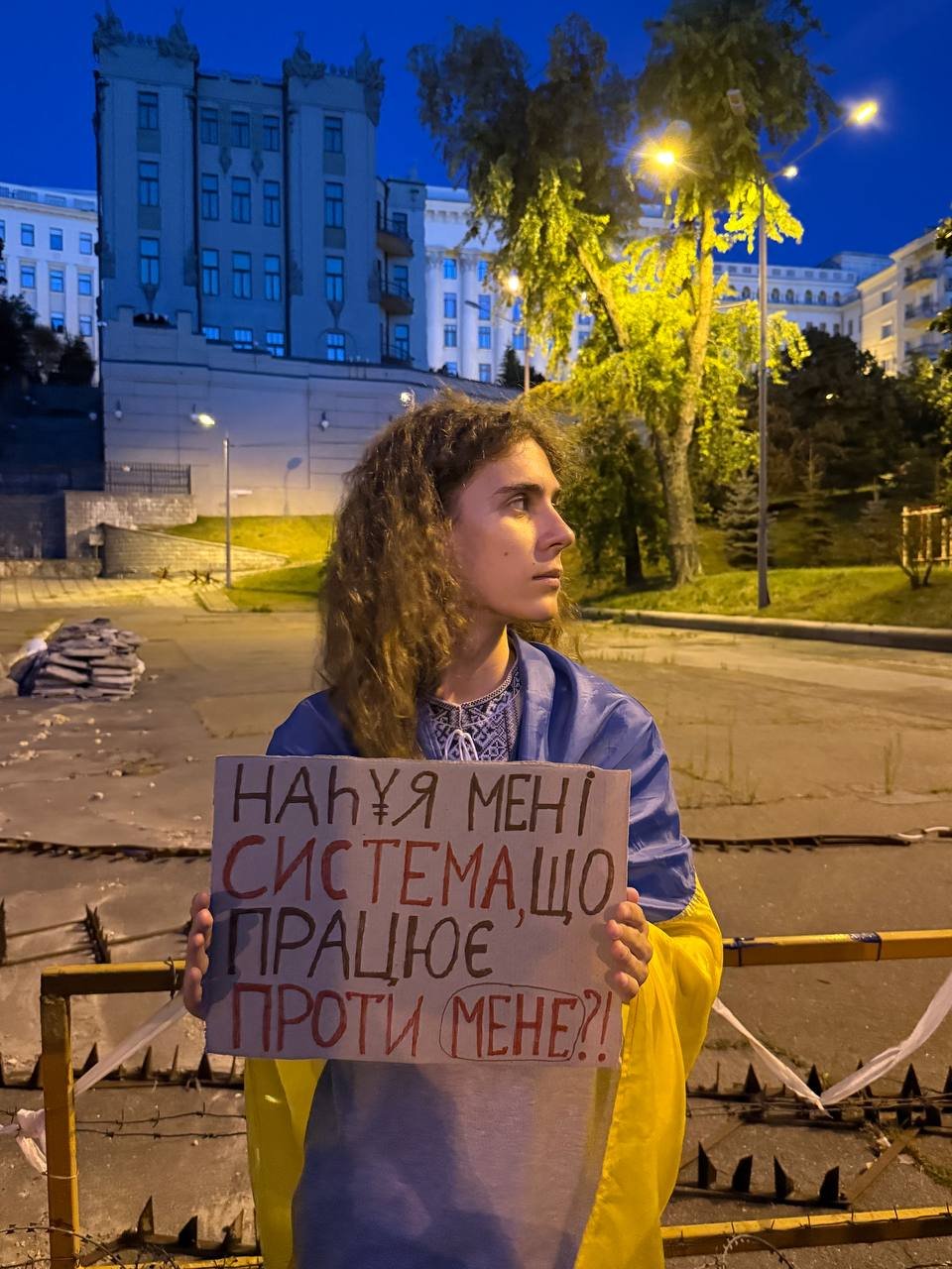 Максим Веремій тримає плакат із цитатою з пісні Сергія Жадана «Автозак»
