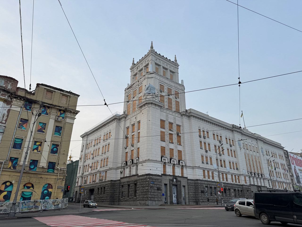 Харківська міська рада. Після російських обстрілів її забиті фанерою вікна стали одним із символів стійкості самоврядування. Місто як обложена фортеця. Однак, попри близькість фронту, Харкову не призначили міську військову адміністрацію