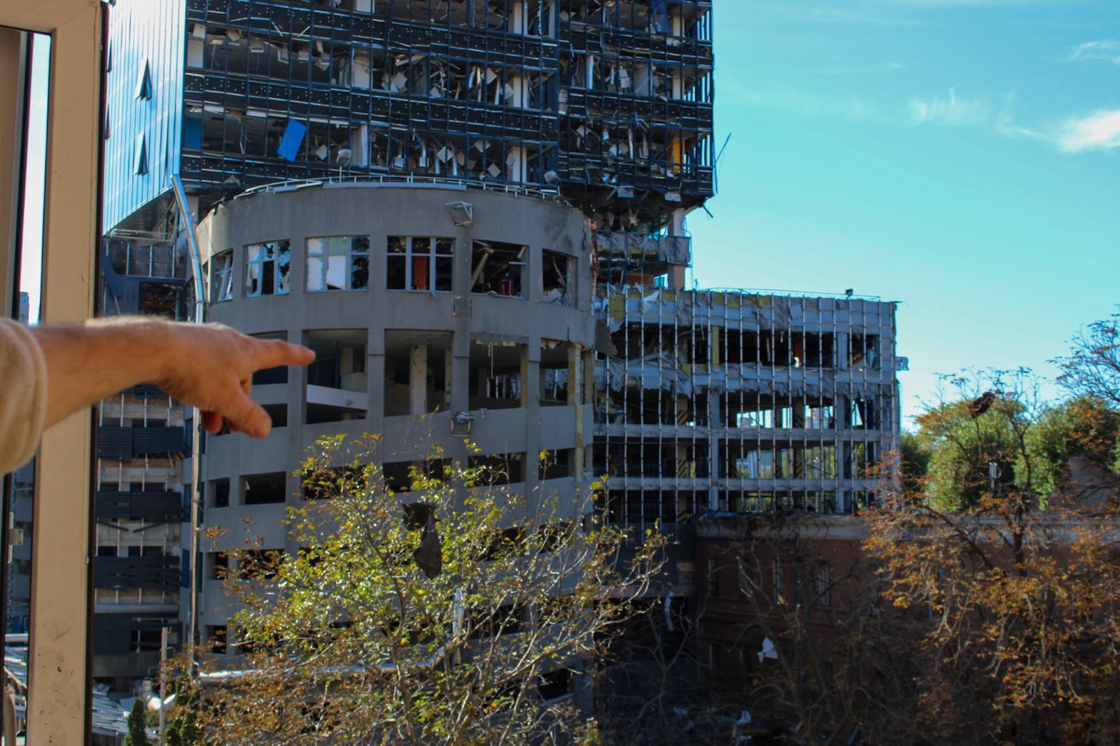 Юрій показує зі свого балкона будівлю, у яку влучила ракета