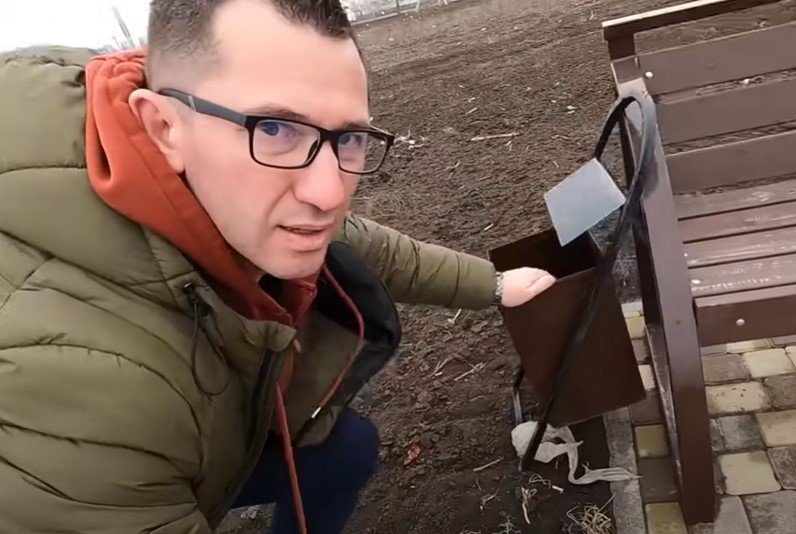 Yevheny demonstrates a garbage bin, which he believes was broken by pro-Ukrainian activists