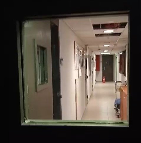 Вид на коридор із віконця у дверях тюремної камери