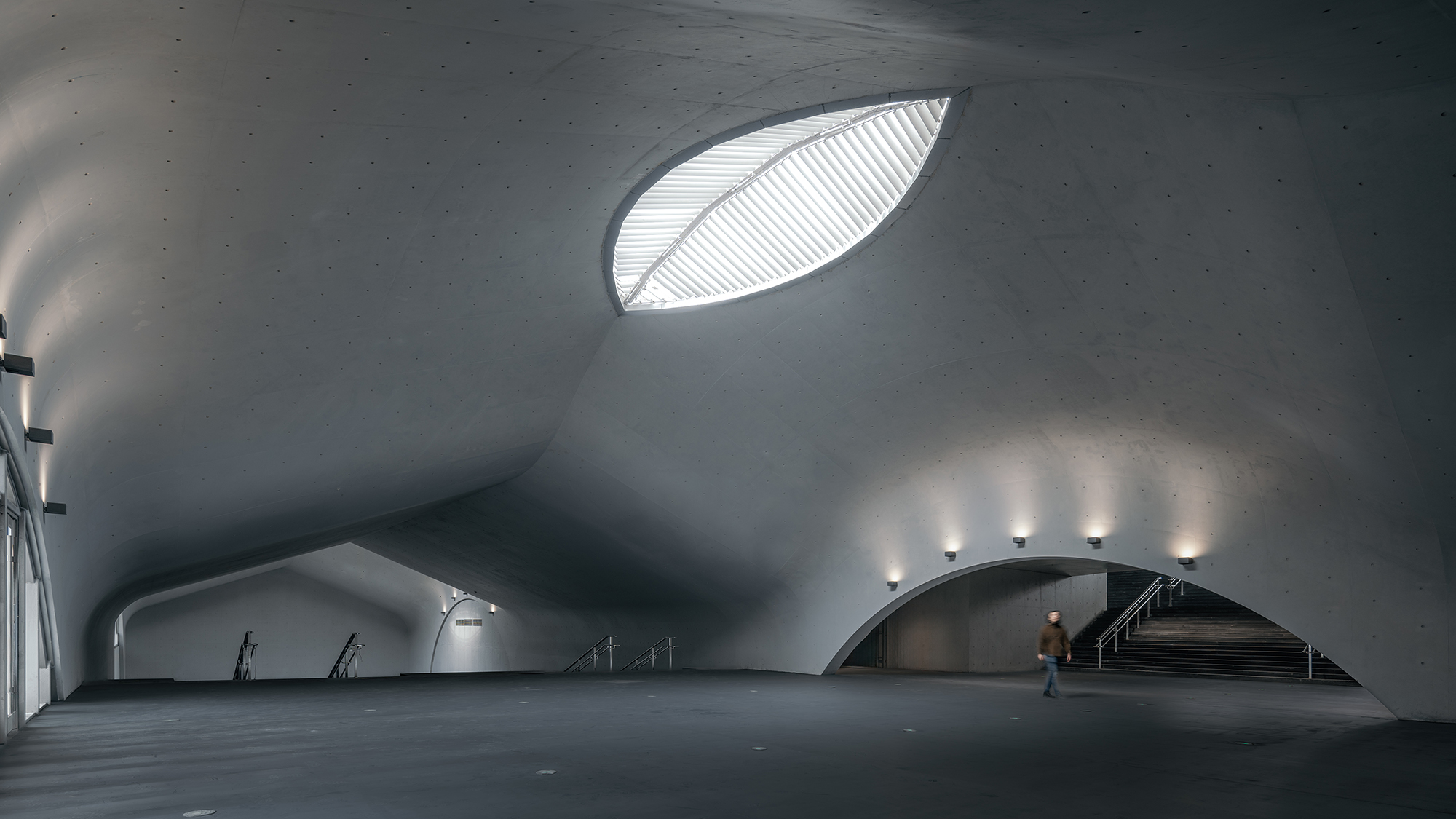 Палац глибокого часу, Китай, від Wutopia Lab. Це підземний художній музей у Чанчуні, увінчаний хвилястим бетонним дахом, пронизаним отворами у формі очей, які підкреслюють відчуття занурення під воду. Фото CreatAR Images