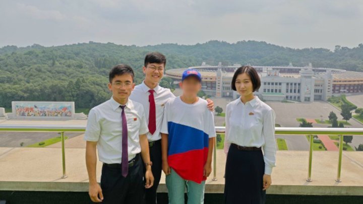 12-річний житель Макіївки, який відвідав табір “Сондовон” у КНДР, із представниками табору. Липень 2025-го. Фото з російських соцмереж