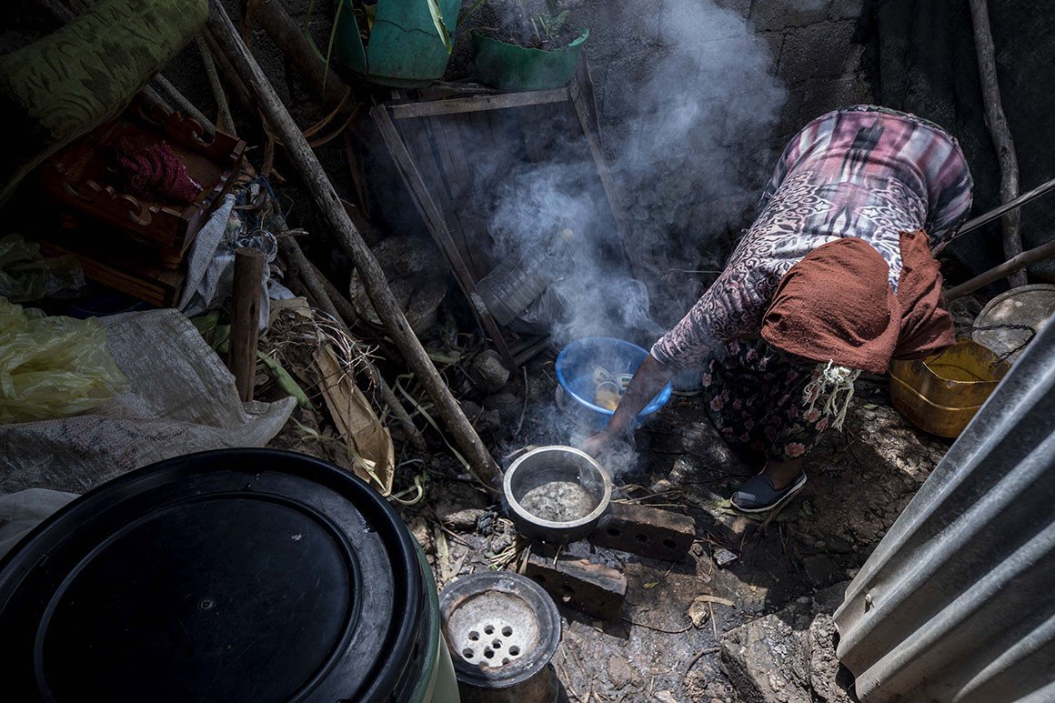 Жінка, яка втратила роботу через пандемію, готує їжу для своєї родини в саморобному житлі – Аддіс-Абеба, Ефіопія, фото AP Photo/Mulugeta Ayene