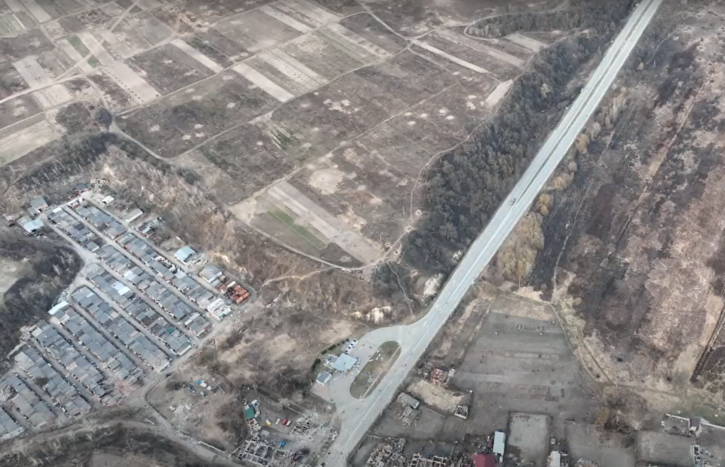 Місце, де йшли бої. Автомобіль Володимира Андрійченка стоїть понад трасою, приблизно посередині цього фото, біля зеленого пагорба. Фото з військового дрона, зняте після відступу росіян, квітень 2022 року.