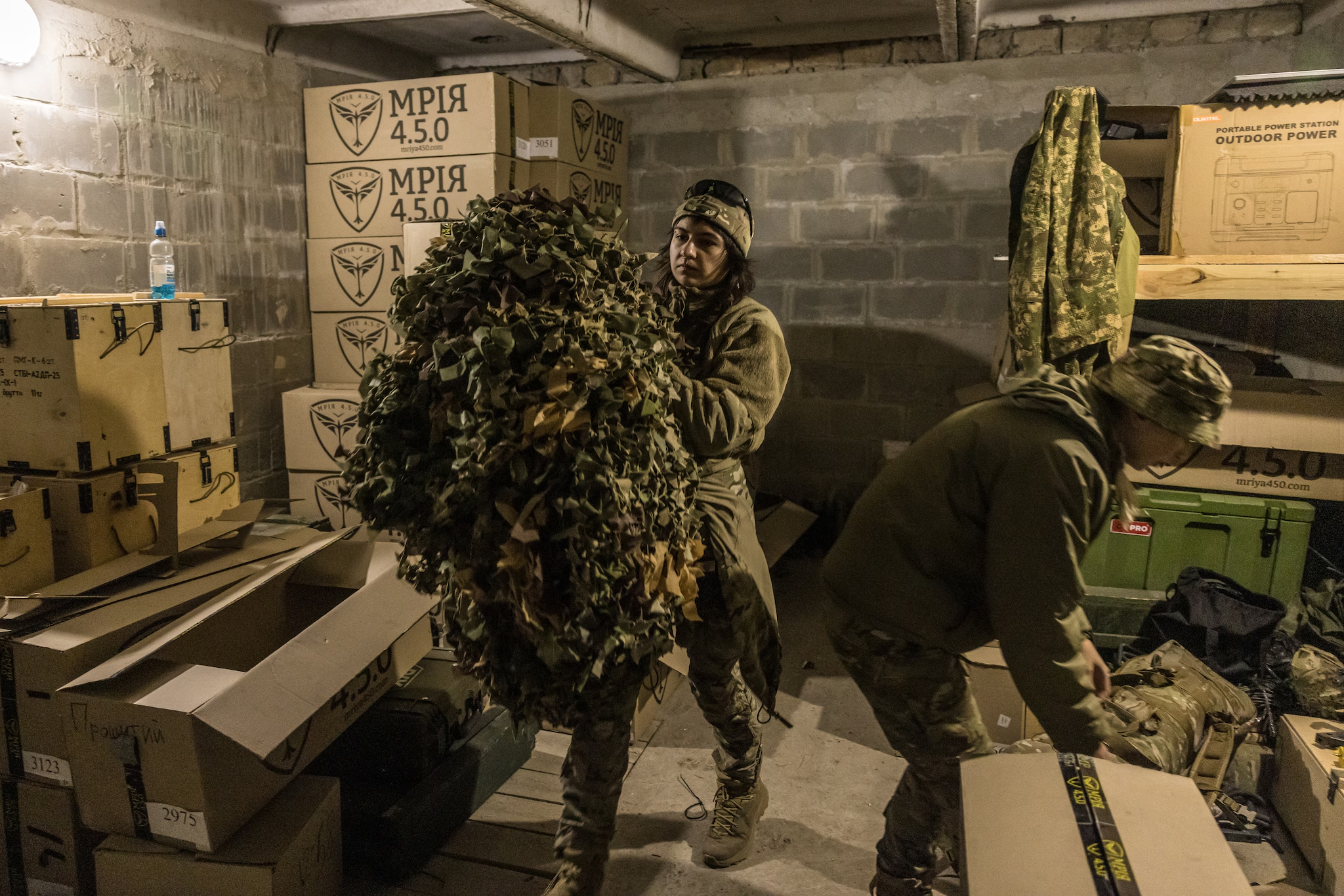 Вікторія несе маскувальні сітки