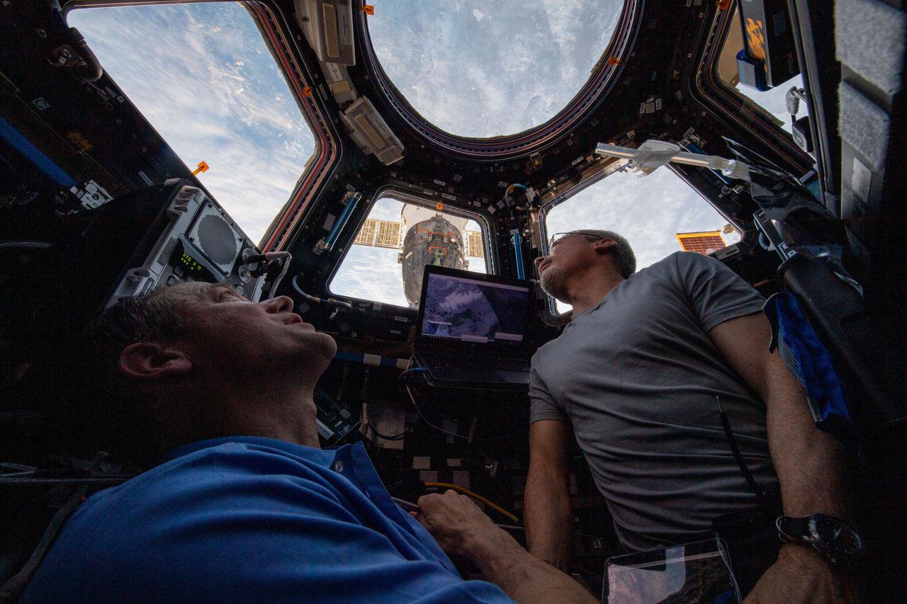 Бортінженери експедиції 66 (зліва направо) Томас Маршберн і Марк Ванде Хей дивляться на Землю з купола з сімома вікнами, який є вікном МКС у світ. Дослідження Crew Earth Observations надає науковцям ключові дані з точки зору МКС, щоб зрозуміти, як Земля змінюється з часом