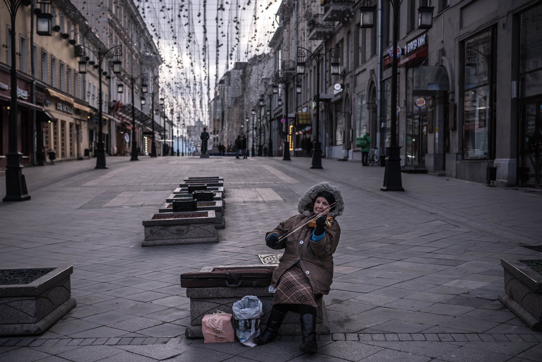 Літня жінка грає на скрипці, просячи гроші, в центрі Москви під час так званих неробочих днів – евфемізму для офіційно не введеного карантину: фото New York Times